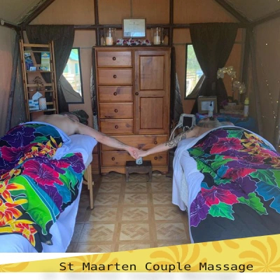 two clients holding hands while on massage table for a couple massage at airbnb in SXM