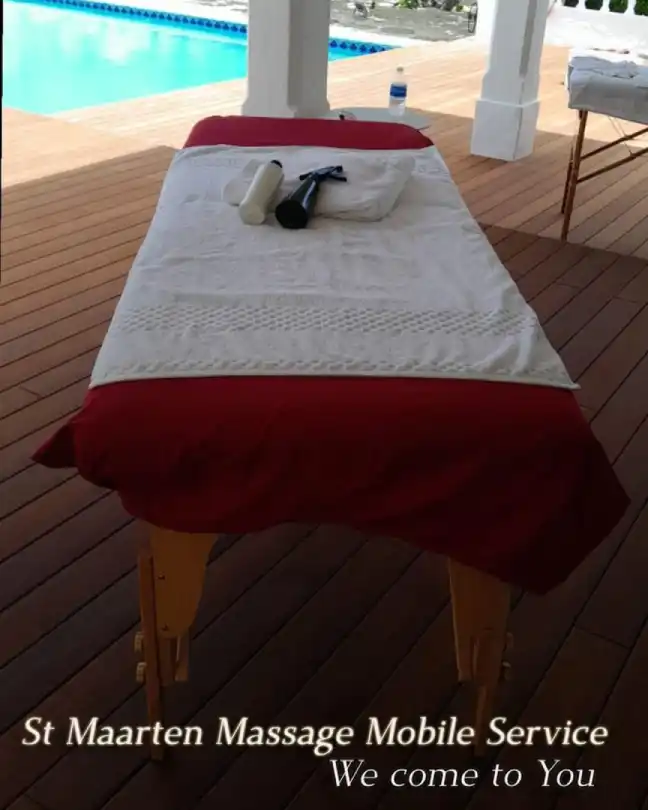 St Maarten Massage Mobile Spa Relaxation Massage
 at villa with massage table with red linen and white towel by the pool with text that reads: st maarten massage mobile service- we come to you